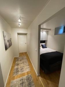 a small bedroom with a bed and a mirror at Revtind - Modern apartment with free parking in Narvik
