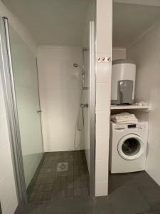 een kleine badkamer met een wasmachine en een wasmachine bij Revtind - Modern apartment with free parking in Narvik