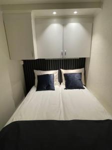 a bed with two blue pillows on top of it at Revtind - Modern apartment with free parking in Narvik