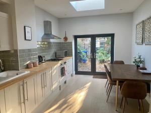 a kitchen with a table and a dining room at Delightful 2 Bedroom House Central Windsor in Windsor