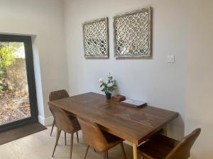 a dining room with a wooden table and chairs at Delightful 2 Bedroom House Central Windsor in Windsor
