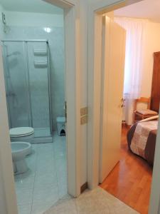 a bathroom with a shower and a toilet and a bed at Ca' Rosa in Trento