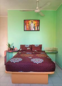 a bedroom with a bed with a purple comforter at El Ultimo Maya in Akumal