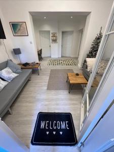 a welcome mat on the floor of a living room at Large Three bed Two bathroom flat in Central Torquay in Torquay
