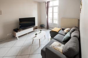 sala de estar con 2 sofás y TV de pantalla plana en Le Neptune Apt 85m2 3ch Appart Hotel Poitiers en Poitiers