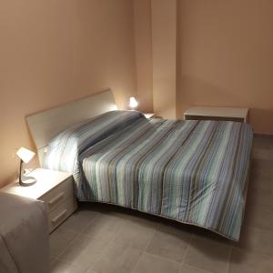a bedroom with a bed with a striped bedspread at Room & Breakfast Santa Maria in Reggio Emilia