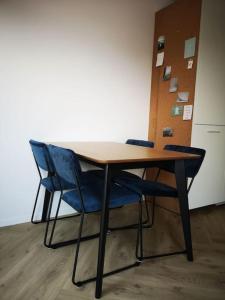 une table en bois avec deux chaises bleues assises dans l'établissement Lanterfant, à Nes