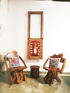 康提的住宿－Barefoot Inn Kandy，客房内的2把椅子和镜子
