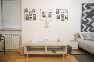 un soggiorno con tavolino e letto di APARTIQUE ZAGREB studio apartman a Zagabria