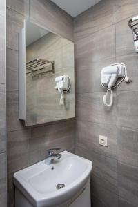GeoGraphy Hotels في غودواري: حمام مع حوض ومرآة