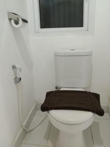 a bathroom with a toilet with a brown towel on it at SMART Dream Inn in Tangerang