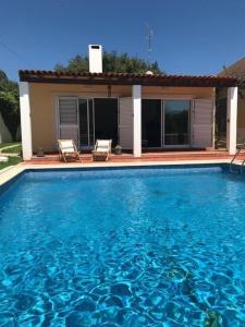 - une piscine avec 2 chaises en face d'une maison dans l'établissement A Casa da Lua, à Tomar