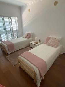 - une chambre avec 2 lits, un canapé et une fenêtre dans l'établissement A Casa da Lua, à Tomar