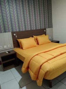SMART Dream Inn في تانغيرانغ: غرفة نوم بسرير مع شراشف صفراء ونافذة
