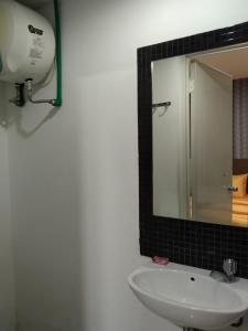 SMART Dream Inn في تانغيرانغ: حمام مع حوض أبيض ومرآة