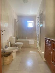 La salle de bains est pourvue de 2 toilettes, d'un lavabo et d'une baignoire. dans l'établissement A Casa da Lua, à Tomar