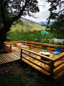 eine Holzterrasse mit einem Stuhl darüber in der Unterkunft Tierras Mágicas in Villa Pehuenia