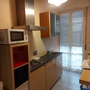una cucina con forno a microonde e piano cottura forno superiore di Room & Breakfast Santa Maria a Reggio Emilia