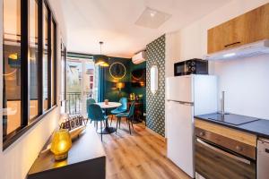 a kitchen with a white refrigerator and a table with chairs at Appartement Emeraude in Martigues