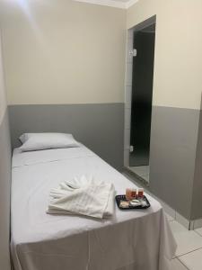 un letto con tavolo, asciugamano e specchio di Hotel Barão Ribeirão a Ribeirão Preto