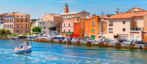 a boat traveling down a river in a city at Appartement Emeraude in Martigues