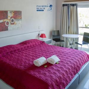 1 dormitorio con 1 cama grande y 2 toallas. en Palmeras Beach Hotel, en Punta del Este