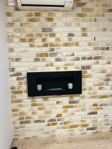 a wall with a brick wall with a television on it at TOP PROPERTIES AND HOME in Voluntari