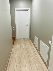 a hallway with a white door and a wooden floor at TOP PROPERTIES AND HOME in Voluntari