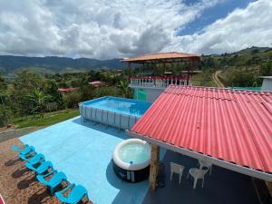 een resort met een zwembad en een rood dak bij Finca Villa Maju in Papagalleros