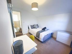 a bedroom with a bed and a table and a desk at Central 4 bed-Reading City Centre in Reading