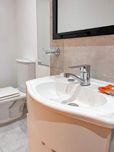 y baño con lavabo blanco y aseo. en BORGES HOUSE APARTS Apartamentos a dos cuadras del obelisco! en Buenos Aires