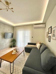ein Wohnzimmer mit einem Sofa und einem Tisch in der Unterkunft Evelyn's Apartment in Alexandroupoli