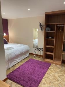 a bedroom with a bed and a purple rug at The King Alfred in Street