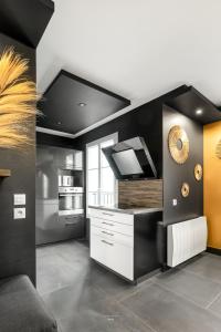 uma cozinha com uma cozinha a preto e branco em Disneyland-Dream 8 pers,2 parking, Wifi, Netflix em Serris
