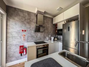 a kitchen with a sink and a refrigerator at Casas Dona Matilde in Torre de Moncorvo