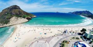 a group of people on a beach near the ocean at Pousada Village Rio Centro in Rio de Janeiro