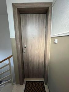 uma porta de madeira num corredor com um tapete em Room with a view em Drama