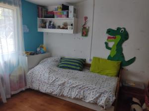 a bedroom with a bed with a dinosaur mural on the wall at Casa en Solymar, 2 dormitorios in Ciudad de la Costa