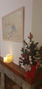 Un albero di Natale seduto su un mantello con una candela di Agradable apartamento con jardín privado en Cerler a Cerler