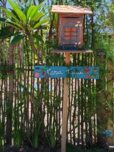 a bird house on a sign in front of a fence at Casa Tatuí in Pôrto de Pedras