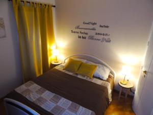 a bedroom with a bed with two lamps and words on the wall at Ca' Rosa in Trento