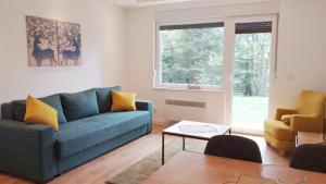 a living room with a blue couch and a table at Apartmani Šišarka in Kopaonik