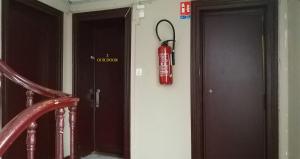 a fire extinguisher hanging on a wall next to two doors at HAUSSMANN ESPACE in Paris