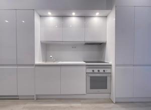 a white kitchen with white cabinets and a sink at Batuecas Plaza Castilla - 4 dormitorios in Madrid
