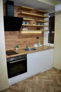 een keuken met een wastafel en een fornuis bij Pink House Apartments in Jagodina