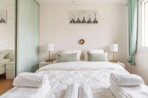 a bedroom with a large white bed with two lamps at FERY HOME 76 - Au Paradis Caché de Rouen in Notre-Dame-de-Bondeville