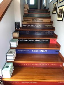 a stack of books sitting on a wooden staircase at La scala del libro in Santo Stefano di Rogliano