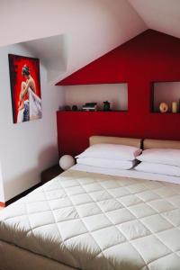 um quarto com uma cama grande e uma parede vermelha em La scala del libro em Santo Stefano di Rogliano