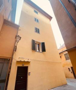 ein hohes Gebäude mit einer Tür und einem Fenster in der Unterkunft San Ranieri Tiny Tower in Pisa