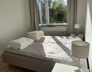 a bed sitting in a room with a window at Stockholm Apartment Hammarbyhöjden in Stockholm